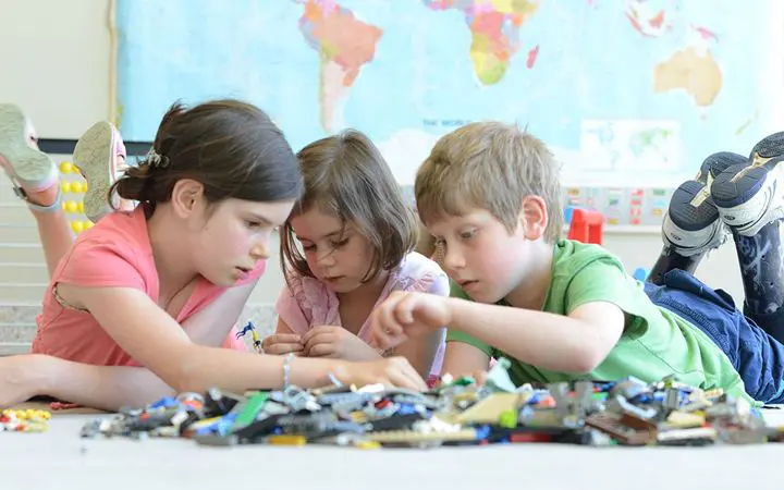 Three kids playing with legos together
